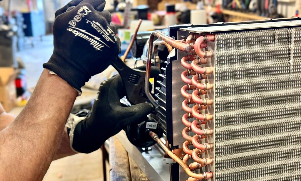 Technician repairing a refrigeration condenser coil