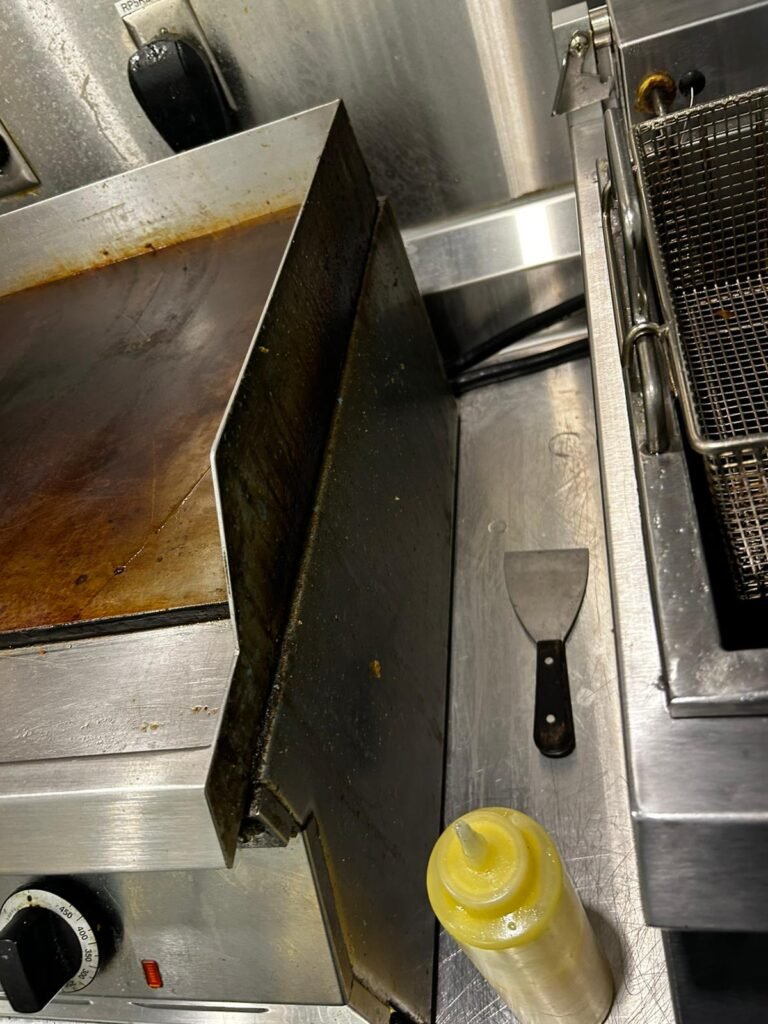 Commercial kitchen griddle before deep cleaning